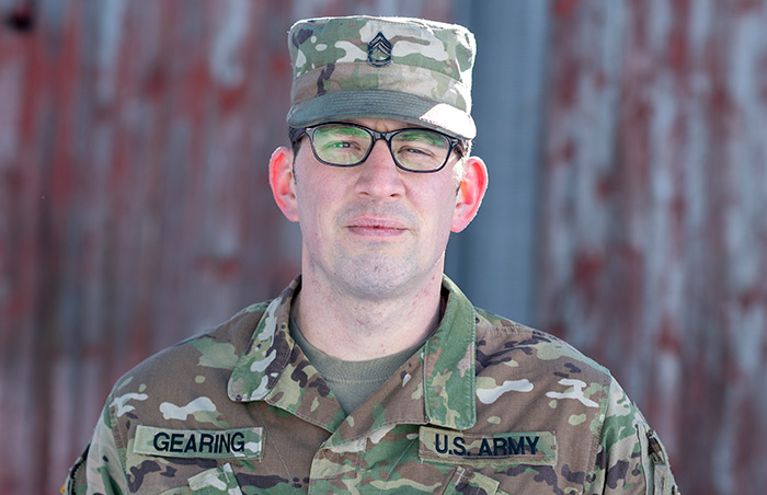 National Guard Dairy Farmer in front of barn
